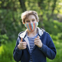 Little Boy Enjoying Hiking In Forest During The COVID 19 Pandemic